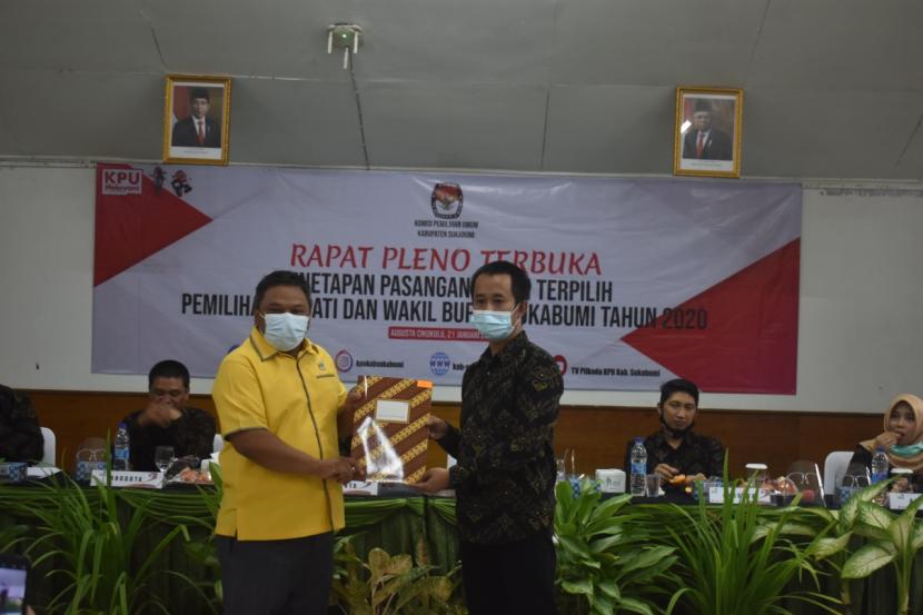 Ketua KPU Kabupaten Sukabumi Ferry Gustaman (kanan) memberikan berkas penetapan bupati dan wakil bupati terpilih kepada paslon, Kamis (21/1)