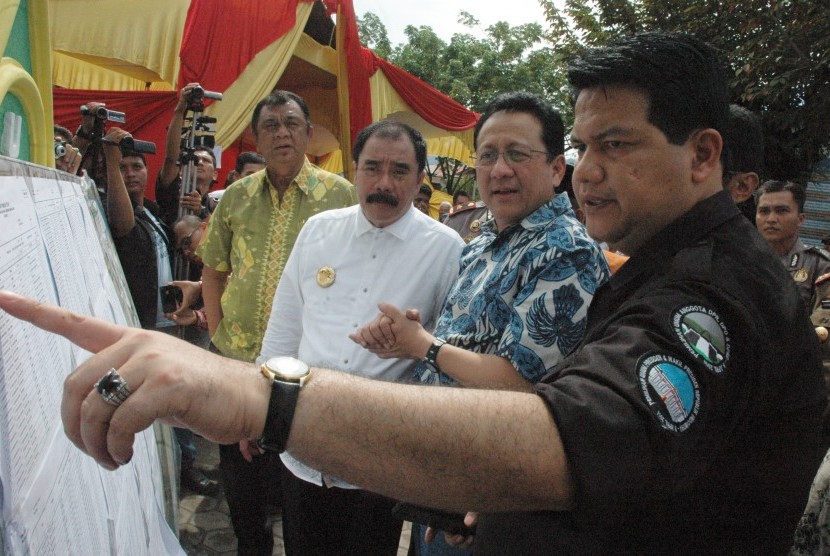 Ketua KPU Pusat Husni Kamil Manik (kanan) memberi keterangan Daftar Pemilih Terdaftar (DPT) kepada Ketua DPD Irman Gusman (dua dari kanan), di TPS 8 Kawasan Dangau Teduh, Padang, Sumatera Barat, Rabu (9/12).