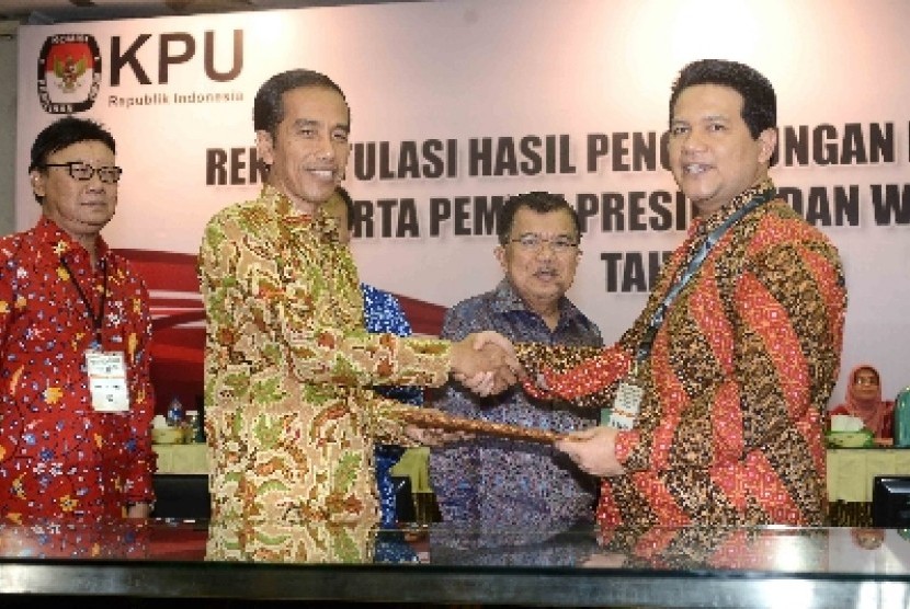 Ketua KPU RI, Husni Kamil Manik (kanan) memberikan hasli rekapitulasi penghitungan suara nasional dan luar negeri pemilihan Presiden 2014 kepada Presiden terpilih Joko Widodo di Gedung KPU, Jakarta, Selasa (22/7). 