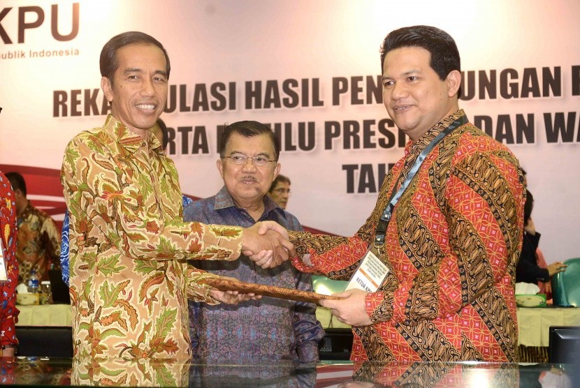 Ketua KPU RI, Husni Kamil Manik memberikan hasil rekapitulasi penghitungan suara nasional dan luar negeri pemilihan Presiden 2014 kepada Presiden terpilih, Joko Widodo di Gedung KPU, Jakarta, Selasa (22/7). 