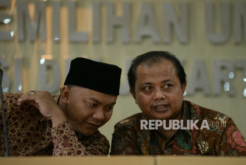 Ketua KPUD DKI Jakarta Sumarno (kanan) dan anggota KPUD DKI Jakarta M Fadillah berbincang disela konferensi pers di Media Center KPU Jakarta, Jumat (21/10). 