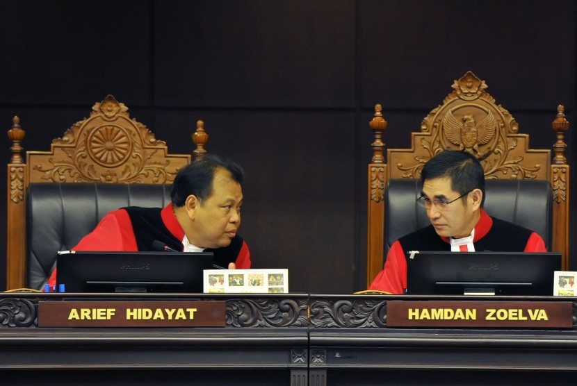Ketua Mahkamah Konstitusi (MK) Hamdan Zoelva (kanan) berdiskusi dengan Hakim MK Arief Hidayat (kiri) saat memimpin sidang pembacaan putusan sengketa Pemilihan Presiden di Gedung MK, Jakarta, Kamis (21/8).