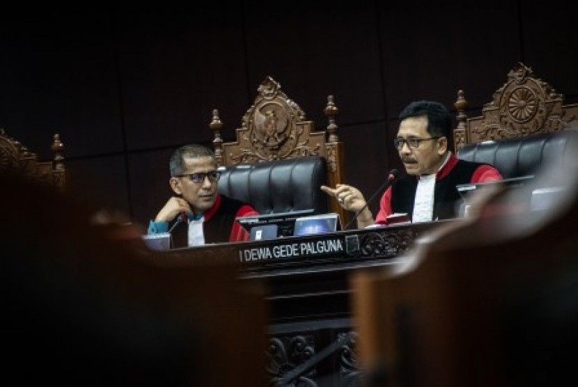 Ketua Majelis Hakim Mahkamah Konstitusi (MK) Saldi Isra (kiri) menyimak penjelasan anggota Majelis Hakim (MK) I Dewa Gede Palguna (kanan) dalam sidang pendahuluan permohonan terkait batas usia calon kepala daerah di Gedung Mahkamah Konstitusi, Jakarta, Rabu (16/10/2019). Sidang tersebut menguji Undang-Undang Nomor 1 Tahun 2015 tentang Penetapan Peraturan Pemerintah Pengganti Undang-Undang Nomor 1 Tahun 2014 tentang Pemilihan Gubernur, Bupati, dan Wali Kota terhadap Undang-Undang Dasar Negara Republik Indonesia 1945. 