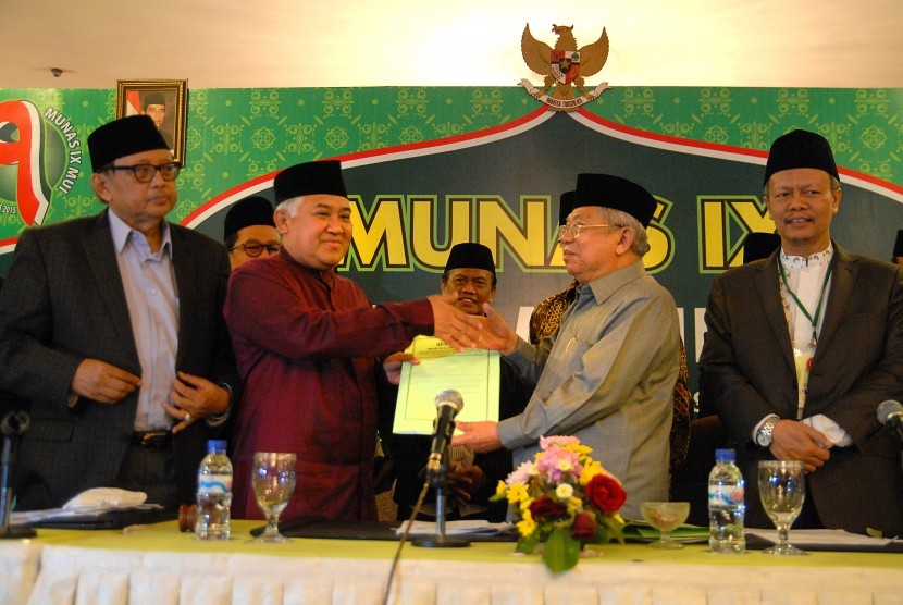 Ketua Majelis Ulama Indonesia (MUI) terpilih, Ma'ruf Amin (kedua kanan) menerima hasil rapat tim formatur dari ketua MUI yang lama Din Syamsuddin (kiri) disela-sela penutupan Musyawarah Nasional (Munas) IX MUI di Surabaya, Jawa Timur, Kamis (27/8) dini har