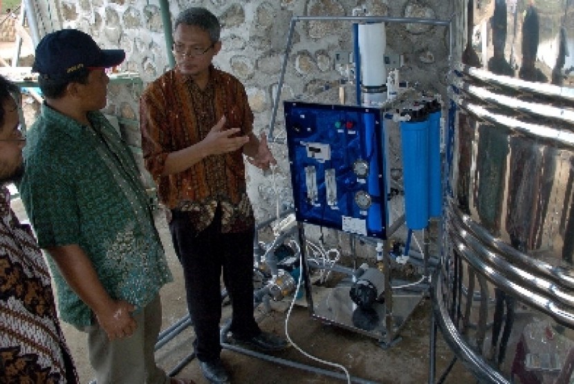 Ketua Masyarakat Nano Indonesia dan Pendiri Nanocenter Indonesia, Nurul Taufiqu Rochman (kanan), menjelaskan fungsi dan cara kerja alat penyulingan air, di Desa Penyaring, Kecamatan Moyo Utara, Kabupaten Sumbawa Besar, NTB.