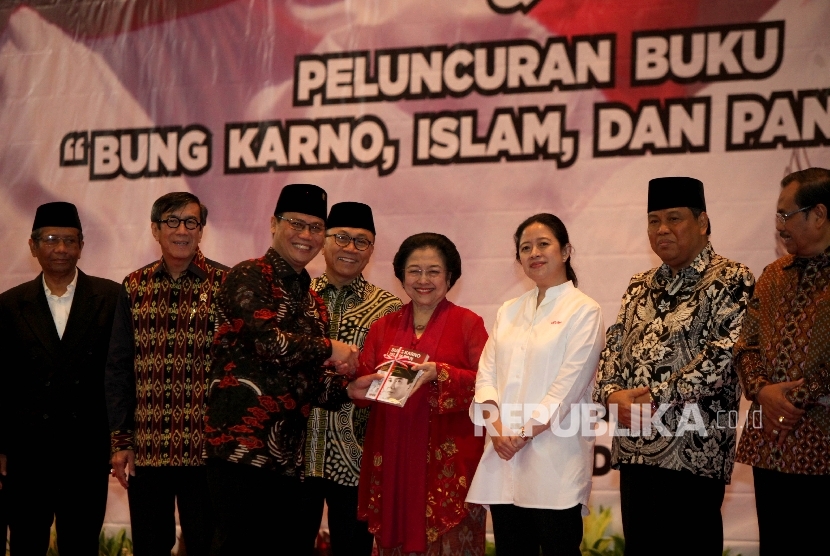 Ketua MPR RI Zulkifli Hasan, menerima buku secara simbolik oleh Ketua Fraksi PDIP di MPR Ahmad Basarah disaksikan Ketua Umum Partai Demokrasi Indonesia Perjuangan sekaligus Presiden RI ke-5, Megawati Soekarnoputri, Ketua Mahkamah Konstitusi (MK), Arief Hidayat , mantan Ketua Mahkamah Konstitusi Mahfud MD , dan Menteri Perekonomian Bidang Pemberdayaan Manusia dan Kebudayaan (Menko PMK) Puan Maharani saat menghadiri peringatan haul Presiden RI pertama, Soekarno, ke-47 sekaligus peluncuran buku karangan Ketua Fraksi PDIP di MPR Ahmad Basarah 'Bung Karno, Islam, dan Pancasila' di kompleks Parlemen, Senayan, Jakarta, Rabu (21/6). 