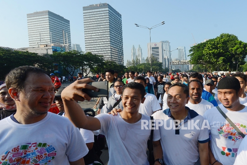  Ketua MPR Zulkifli Hasan (kedua kanan) berswafoto besama warga saat mengikuti jalan santai Walk For Unity saat Hari Bebas Kendaraan Bermotor (BKB) di Jalan M.H Thamrin, Jakarta, Ahad (3/4).(Republika/Raisan Al Farisi)