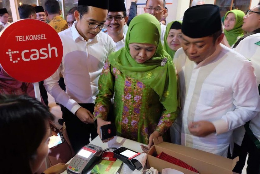 Ketua Muslimat NU Khofifah Indar Parawansa didampingi Direktur Utama Telkomsel Ririek Adriansyah mencoba layanan Tcash