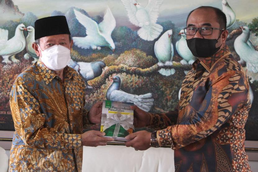 Ketua Pengurus Paguyuban Pasundan Prof Didi Turmudzi (kiri) menerima buku dari alumni Unpas Iyus Suryana (kanan).