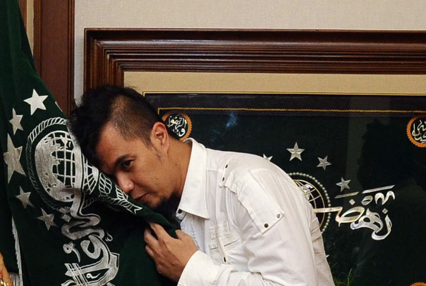Ketua Seni dan Kebudayaan NU, Ahmad Dhani, mencium bendera NU usai diberikan pin ketua Seni dan Kebudayaan dalam tasyakuran Harlah PBNU ke-91 di Jakarta, Jumat (16/5).