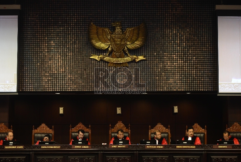 Ketua Sidang Mahkamah Konstitusi Arief Hidayat (keempat kiri) membacakan putusan sidang atas gugatan UU Otoritas Jasa Keuangan (OJK) di Mahkamah Konstitusi, Jakarta, Selasa (4/8).     (Republika/Raisan Al Farisi)