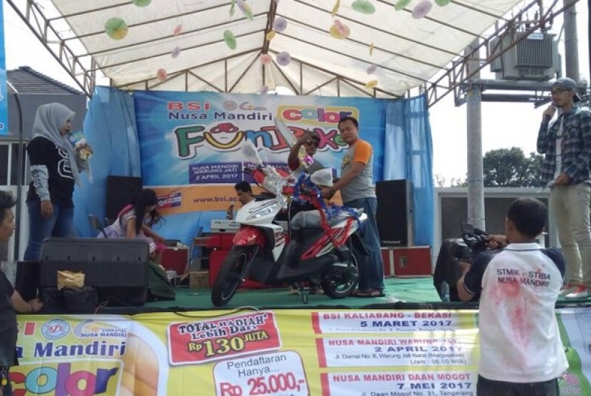 Ketua STMIK Nusa Mandiri Mochamad Wahyudi menyerahkan hadiah utama satu unit sepeda motor kepada peserta  Color Fun Bike 2017 yang beruntung. 