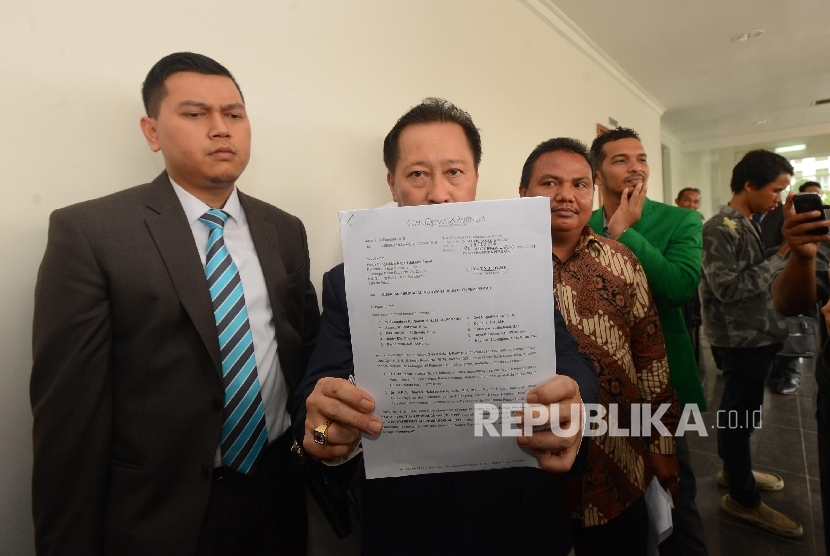 Ketua Tim Kuasa Hukum PPP, Humphrey R Djemat (kedua kiri) menunjukan surat gugatan usai menjalani sidang gugatan perdana di Pengadilan Negeri Jakarta Pusat, Selasa (15/3). 