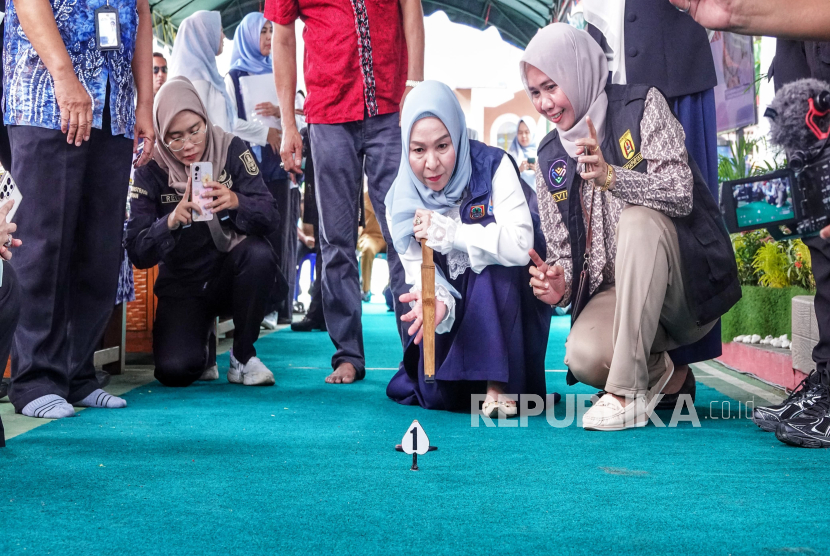 Ketua Tim Pembina Posyandu Provinsi Kalsel Hj Fathul Jannah Muhidin tampak konsentrasi saat membidik logo agar tepat sasaran. 