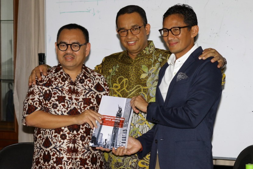 Ketua Tim Sinkronisasi Anies-Sandi, Sudirman Said (kiri) menyerahkan hasil kerja tim sinkronisasi pada pasangan Gubernur-Wakil Gubernur DKI Jakarta terpilih Anies Baswedan (tengah) dan Sandiaga Uno di Jakarta, Jumat (13/10). 