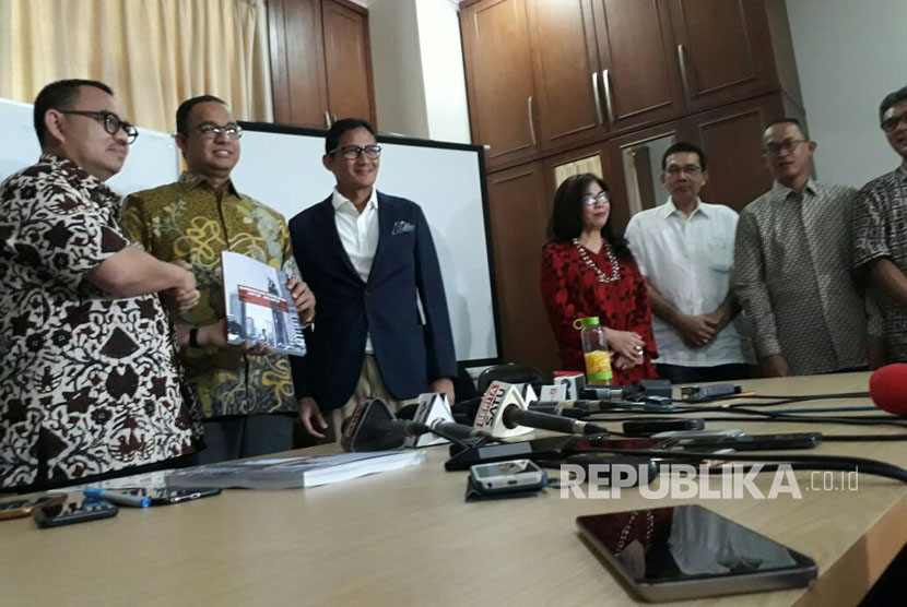 Ketua Tim Sinkronisasi Anies-Sandi, Sudirman Said (kiri) menyerahkan hasil kerja tim sinkronisasi pada pasangan Gubernur-Wakil Gubernur DKI Jakarta terpilih Anies Baswedan (tengah) dan Sandiaga Uno di Jakarta, Jumat (13/10). 