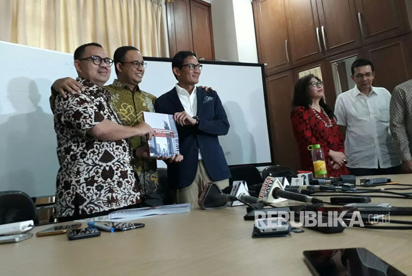 Ketua Tim Sinkronisasi Anies-Sandi, Sudirman Said (kiri) menyerahkan hasil kerja tim sinkronisasi pada pasangan Gubernur-Wakil Gubernur DKI Jakarta terpilih Anies Baswedan (tengah) dan Sandiaga Uno di Jakarta, Jumat (13/10). 