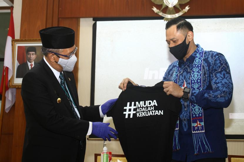 Ketua Umum DPP Partai Demokrat Agus Harimurti Yudhoyono menyerahkan cenderamata kaus kepada Gubernur Kalbar Sutarmidji (kiri) usai bertemu di Kota Pontianak, Kalimantan Barat, Rabu (22/9/2021). 