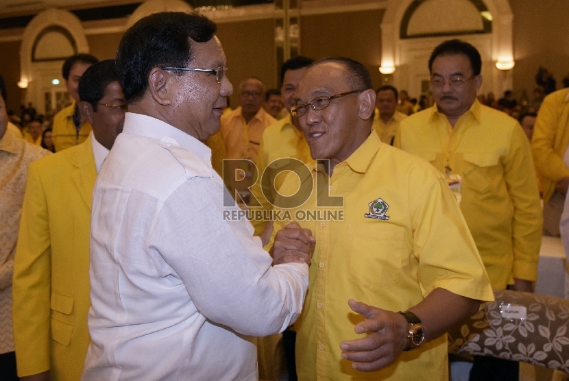 Ketua Umum DPP Partai Golkar Aburizal Bakrie (kedua kanan) bersalaman dengan Ketua Umum Partai Gerindra, Prabowo Subianto (kiri) dalam pembukaan Rapimnas ke VIII Golkar di Jakarta, Jumat (12/6).(ANTARA FOTO/Sigid Kurniawan) 