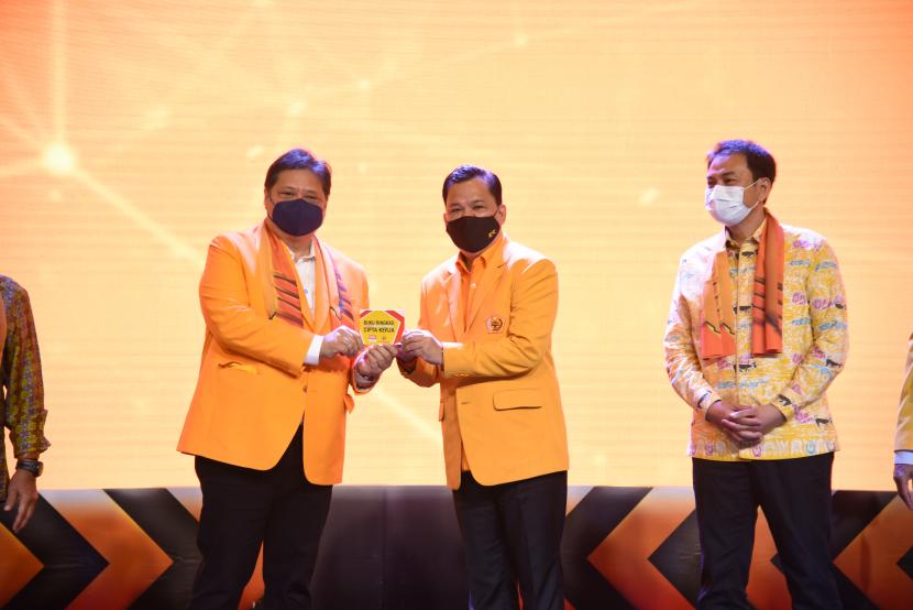 Ketua Umum DPP Partai Golkar Airlangga Hartarto (kiri) menyerahkan Buku Ringkas UU Cipta Kerja kepada Ketua Umum DPP Ormas MKGR Roem Kono (tengah) saat Mubes IX Ormas MKGR di Jakarta, Jumat (30/10).