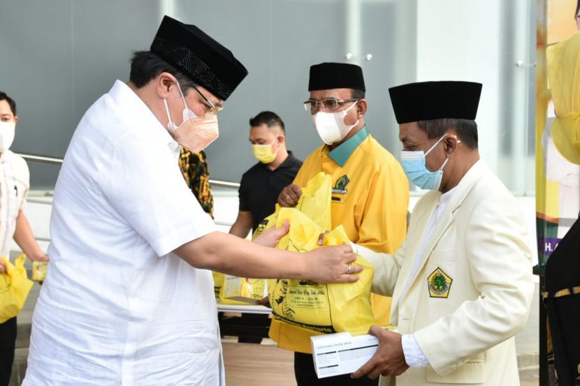 Ketua Umum DPP Partai Golkar Airlangga Hartarto (kiri) menyerahkan bantuan paket sembako dan daging hewan kurban kepada masyarakat di DPP Partai Golkar, Jakarta, Rabu (21/7).