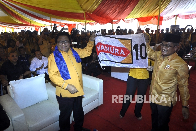 Ketua Umum DPP Partai Hanura Oesman Sapta Odang (kiri) membentangkan bendera Partai Hanura