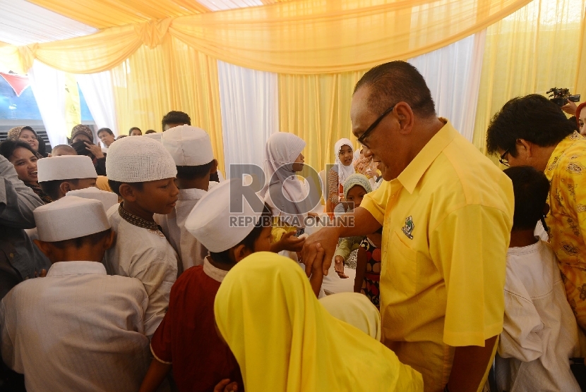 Ketua umum Parta Golongan Karya (Golkar) versi Munas Bali, Aburizal Bakrie menyalami anak yatim saat perayaan HUT Golkar yang ke-51 di Kampung Pulo, Jakarta Timur, Selasa (20/10).