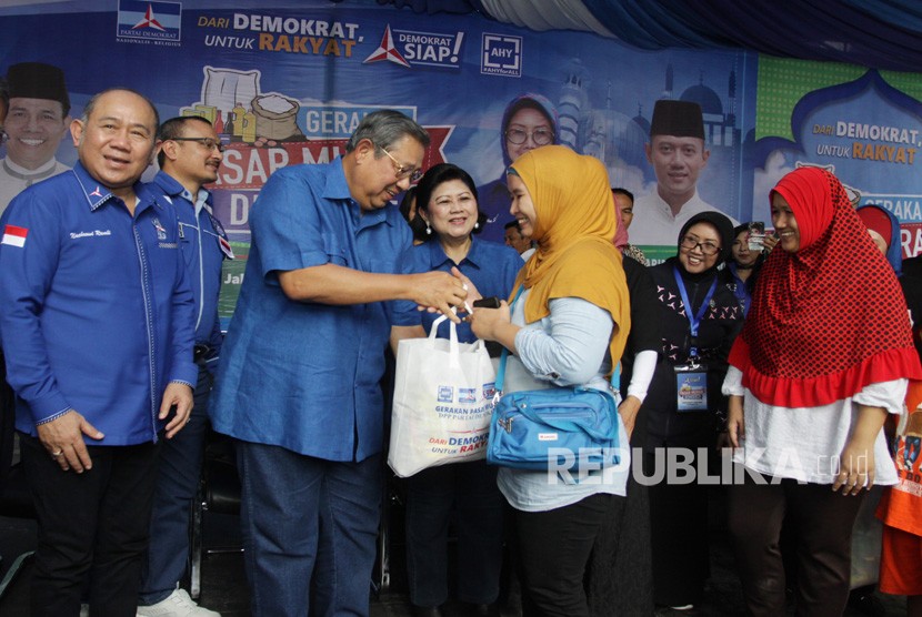 Ketua Umum Partai Demokrat Susilo Bambang Yudhoyono (kedua kiri) didampingi Ibu Ani Yudhoyono dan Politisi Partai Demokrat Nachrowi Ramli (kiri) memberikan paket sembako yang telah dibeli oleh warga saat acara Gerakan Pasar Murah Demokrat di Wisma Proklamasi, Jakarta, Kamis (7/6).