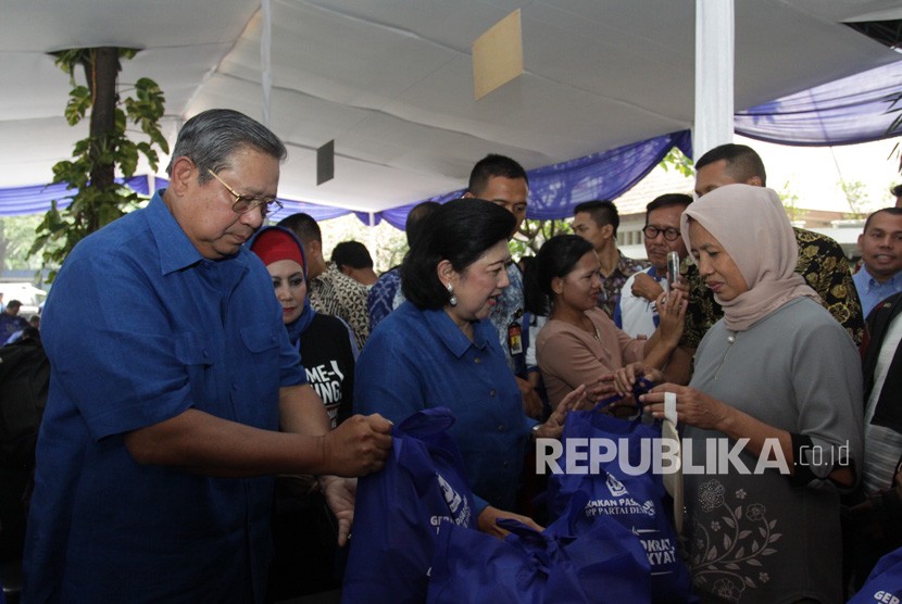 Ketua Umum Partai Demokrat Susilo Bambang Yudhoyono (kiri) didampingi Ibu Ani Yudhoyono memberikan paket sembako yang telah dibeli oleh warga saat acara Gerakan Pasar Murah Demokrat di Wisma Proklamasi, Jakarta, Kamis (7/6).