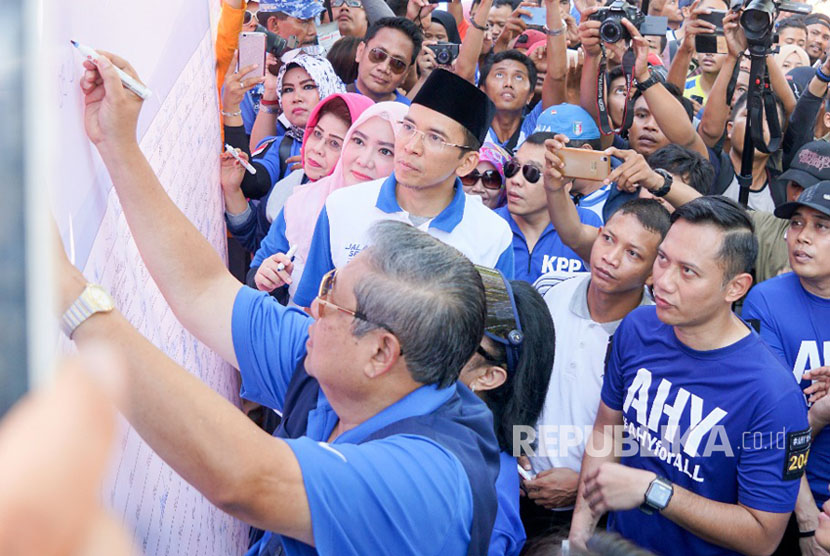 Ketua Umum Partai Demokrat Susilo Bambang Yudhoyono (SBY), Agus Harimurti Yudhoyono (AHY), dan Tuan Guru Bajang (TGB) Muhammad Zainul Majdi menandatangani banner stop hoax dan fitnah di Car Free Day di Mataram, NTB, Ahad (7/5).