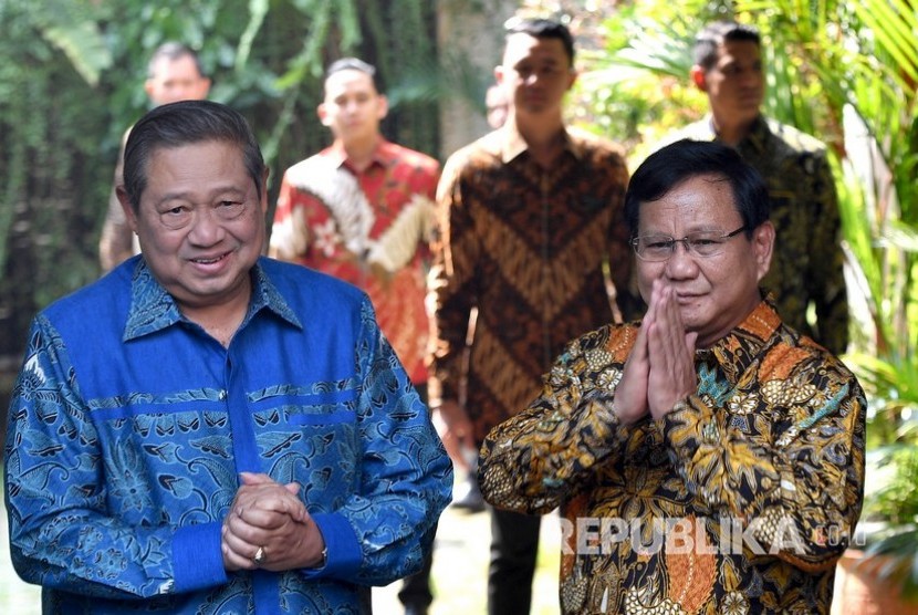 Ketua Umum Partai Gerindra Prabowo Subianto (kanan) dan Ketua Umum Partai Demokrat Susilo Bambang Yudhoyono (kiri) memberikan salam kepada media sebelum melakukan pertemuan tertutup di kediaman Prabowo, Jalan Kertanegara, Jakarta Selatan, Senin (30/7).