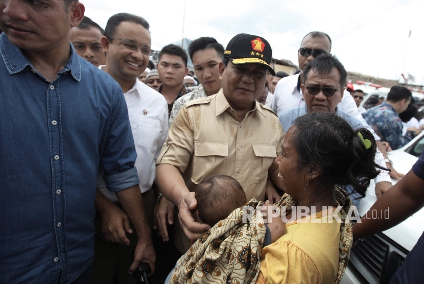 Ketua Umum Partai Gerindra Prabowo Subianto (tengah) bersama calon gubernur DKI Jakarta Anies Baswedan (kedua kiri) mendatangi wilayah Kampung Akuarium, Penjaringan, Jakarta Utara, Sabtu (7/1)