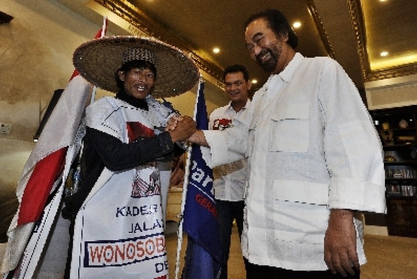 Ketua Umum Partai Nasdem Surya Paloh berjabat tangan dengan simpatisan Nasdem, Nasikun yang berjalan kaki dari Wonosobo.