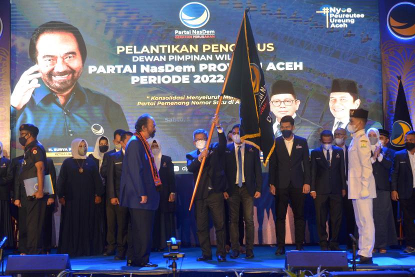Ketua Umum Partai Nasdem Surya Paloh (kiri depan) menyerahkan bendera partai kepada Ketua DPW Partai NasDem Provinsi Aceh Teuku Taufiqulhadi (kanan depan) saat pelantikan pengurus partai periode tahun 2022-2024 bersamaan dengan Rakorwil DPW di Banda Aceh, Aceh, Sabtu (5/3/2022). Rakorwil DPW Partai NasDem Aceh itu digelar untuk penguatan struktur partai dan konsolidasi menyeluruh menuju partai pemenang nomor satu di Aceh.