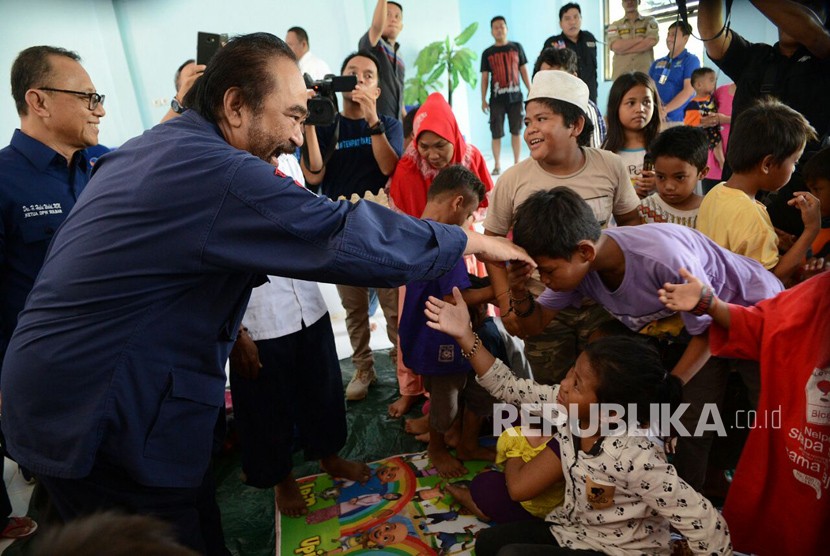 Ketua Umum Partai Nasdem Surya Paloh mengunjungi pengungsi korban banjir di Mamuju, Sulawesi Barat, Ahad (24/3).