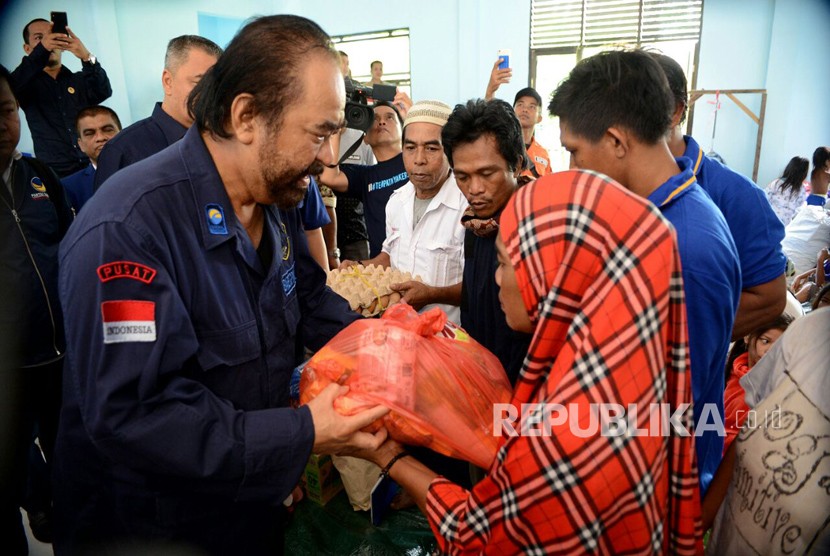 Ketua Umum Partai Nasdem Surya Paloh mengunjungi pengungsi korban banjir di Mamuju, Sulawesi Barat, Ahad (24/3).