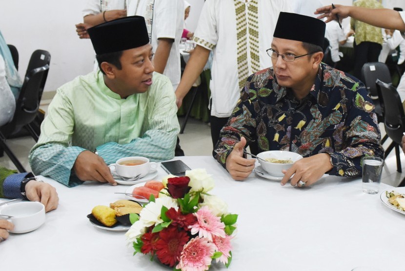 Ketua Umum Partai Persatuan Pembangunan (PPP) versi muktamar Surabaya Muhammad Romahurmuziy (kiri) berbincang dengan Menteri Agama Lukman Hakim Saefuddin (kanan) saat buka bersama DPP PPP di Jakarta, Senin (22/6).