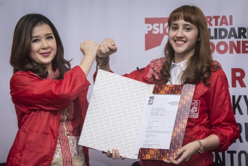 Ketua Umum Partai Solidaritas Indonesia (PSI) Grace Natalie (kiri) bersama Calon Legislatif (Caleg) PSI yang juga Ketua DPP PSI Bidang Eksternal Tsamara Amany (kanan) menunjukkan formulir pendaftaran Tsamara Amany sebagai Caleg PSI di Kantor DPP PSI, Tanah Abang, Jakarta, Kamis (26/10).