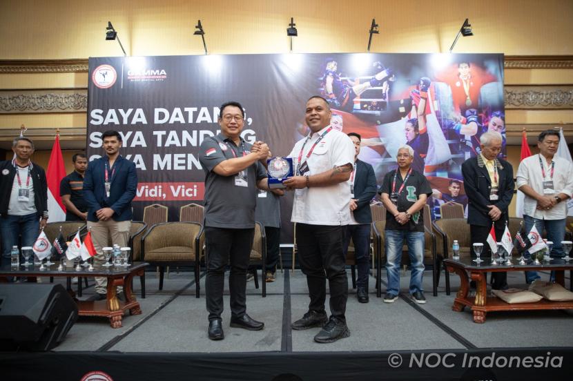 Wakil Ketua Umum PB PERTACAMI  Jovinus Carolus Legawa memberikan cinderamata kepada KE Krisna Bayu dalam Pembukaan Kejuaraan Nasional MMA Amatir U-18 Piala Pertacami I 2024. 