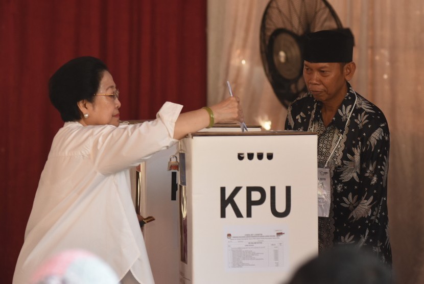 Ketua Umum PDI Perjuangan yang juga Presiden kelima RI Megawati Soekarnoputri memasukkan surat suara saat menggunakan hak pilihnya pada Pemilu 2019 di TPS 62, Kebagusan, Jakarta, Rabu (17/4/2019).