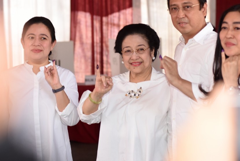 Ketua Umum PDI Perjuangan yang juga Presiden kelima RI Megawati Soekarnoputri (tengah) bersama putrinya Puan Maharani (kiri) dan putranya Muhammad Prananda Prabowo (kedua kanan) menunjukkan jarinya yang telah dicelup tinta seusai menggunakan hak pilihnya pada Pemilu 2019 di TPS 62, Kebagusan, Jakarta, Rabu (17/4/2019).