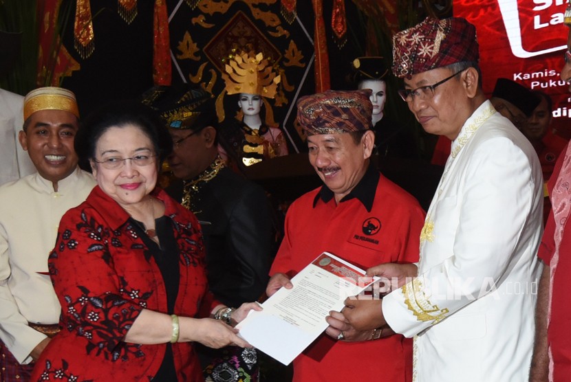 Ketua Umum PDIP Megawati Soekarnoputri (kiri) menyerahkan surat rekomendasi partai kepada pasangan Bacagub-Cawagub Lampung Herman Hasan Nusi (kedua kanan) dan Sutono (kanan) dalam acara penetapan bakal calon gubernur dan wakil gubernur yang diusung PDIP di Jakarta, Kamis (4/1).