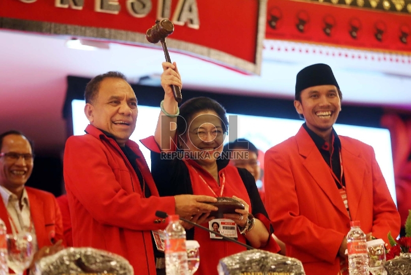  Ketua Umum PDIP Megawati Soekarnoputri (tengah) menerima palu dari Pimpinan Sidang Frans Lebu Raya (kiri) usai pengumuman pengurus DPP PDIP pada Kongres IV PDIP di Sanur, Bali, Jumat (10/4).  (Republika/Tahta Aidilla)