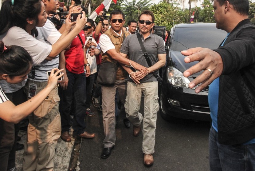 Ketua Umum Persatuan Artis Film Indonesia (PARFI) Gatot Brajamusti alias AA Gatot (kanan) dikawal petugas saat tiba di rumahnya di kawasan Pondok Indah, Jakarta, Kamis (1/9). 
