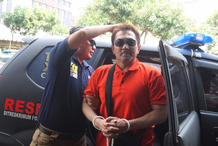 Ketua Umum Persatuan Artis Film Indonesia (PARFI) Gatot Brajamusti alias AA Gatot (kanan) dikawal petugas saat menjalani pemeriksaan di Subdit Resmob Dit Reskrimum Polda Metro Jaya, Jakarta, Senin (5/9). 