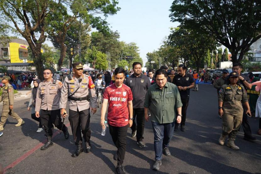Ketua Umum PSSI Erick Thohir (kanan) bersama Wali Kota Solo, Gibran Rakabuming Raka melakukan jalan sehat dari daerah Gendengan ke GOR Sriwedari, Ahad (23/7/2023).