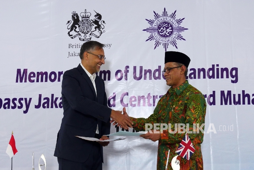 Ketua Umum Pimpinan Pusat Muhammadiyah Haedar Nasir (kanan) dan Duta Besar Inggris untuk Indonesia Moazzam Malik bertukar nota kesepahaman bersamai usai ditandatangani bersama, Senin (16/5) di Jakarta.  (Republika / Darmawan)