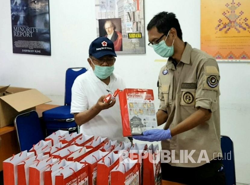 Ketua Umum PMI, Jusuf Kalla (JK) meninjau proses pengepakan paket PHBS yang dilakukan oleh Relawan PMI