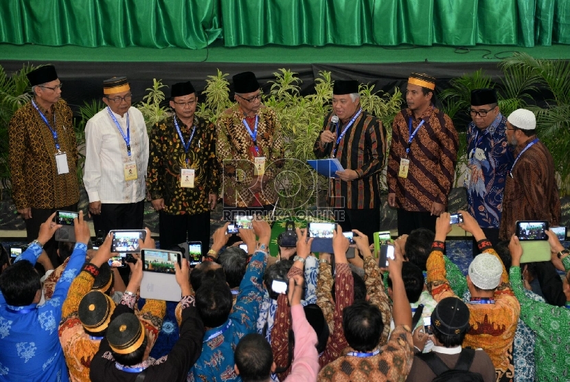 Ketua Umum PP Muhammadiyah 2015-2020 Haedar Nashir (4kiri) dan Ketua Umum PP Muhammadiyah 2010-2015 Din Syamsuddin (4kanan) melakukan serah terima jabatan saat sidang pleno muktamar Muhammadiyah ke 47 di kampus Unismuh Makassar, Sulsel, Jumat (7/8).