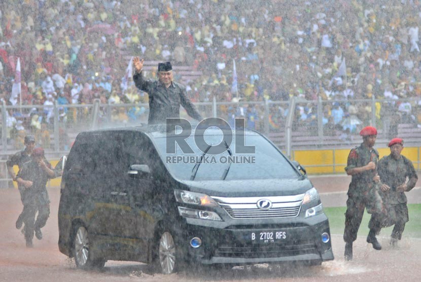  Ketua Umum PP Muhammadiyah Din Syamsuddin menyambut peserta di tengah derasnya hujan dalam acara Milad Seabad Muhammadiyah di Gelora Bung Karno (GBK), Jakarta, Ahad (18/11).  (Republika/Aditya Pradana Putra)